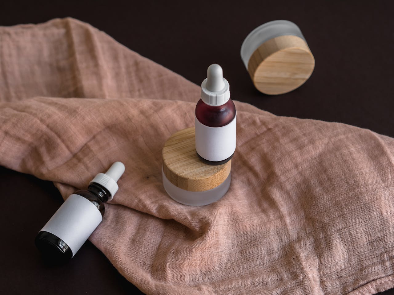 about-me Stylish mockup of glass dropper bottles and containers on a textile background, perfect for branding.